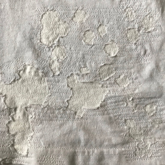 white shirt with many patched holes