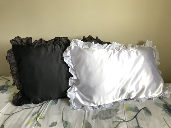 2 sattin pillows with ruffle trim one white one black